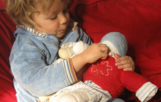 Bildung von Kopf, Herz und Hand - Kind spielt mit Puppe © fuerkinder